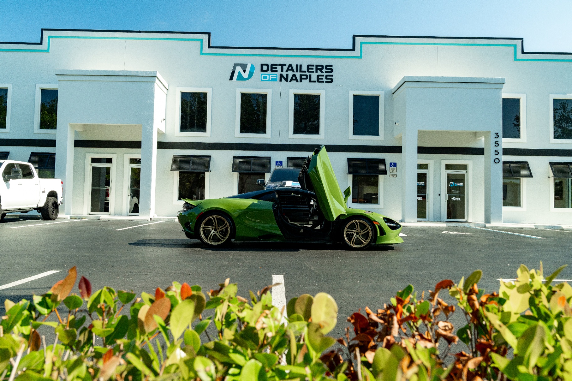 Green McLaren parked in front of the Detailers of Naples shop